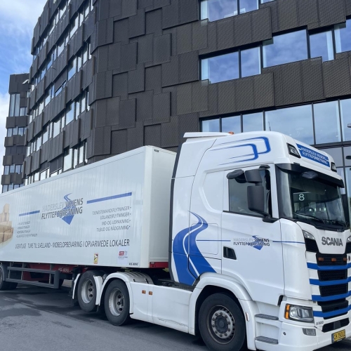 Flyttelastbil parkeret ved SAS bygning under erhvervsflytning. Effektiv flytning for virksomheder.