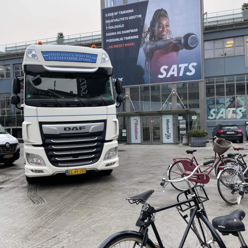 Flyttelastbil foran SATS-fitnesscenter under en erhvervsflytning. Effektiv flytning af udstyr for erhvervskunde.